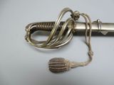 a silver sword with a rope around it on a white surface