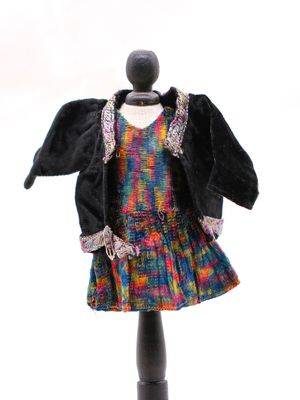 une robe et une veste sur un mannequin posé sur un support