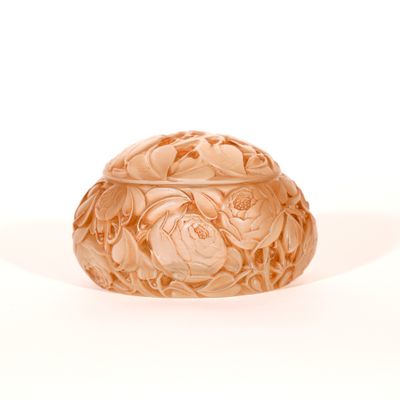 Des motifs de fleurs et de feuilles sont sculptés à la surface d'un bol