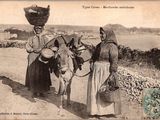 une vieille photo montrant deux femmes et un âne sur un chemin de terre