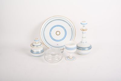 une table blanche avec une assiette bleue et blanche et deux bougeoirs