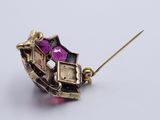 an image of a close up of a broochle with a pink stone