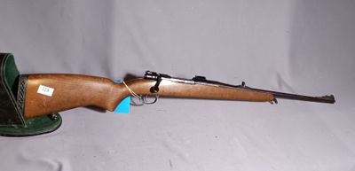 the rifle is sitting on a hat on a white background