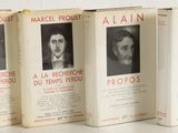 three books on a table with a white background and a black and white photo of three men