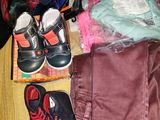 a pile of clothes and a pair of shoes on a table
