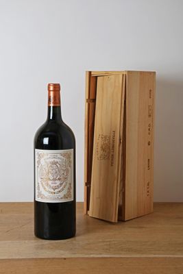 une bouteille de vin posée sur une table, à côté d'une caisse en bois