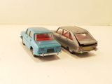 two toy cars sitting next to each other on a white surface