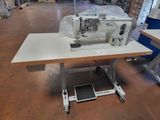 a sewing machine sitting on a table in a warehouse