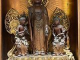 a statue of a woman and two children in a wooden box