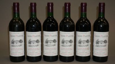 six bouteilles de vin sont alignées sur une table
