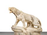 an ivory sculpture of a lion on a rock with its mouth open