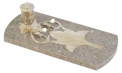 un bougeoir en or et une bougie en argent posés sur une dalle de marbre