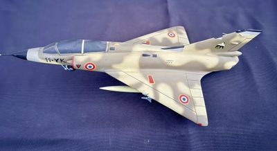 une maquette d'avion de chasse posée sur une surface bleue