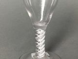 a wine glass with a twisted stem sitting on a table