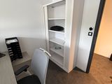 un bureau avec une chaise et une bibliothèque dans un coin