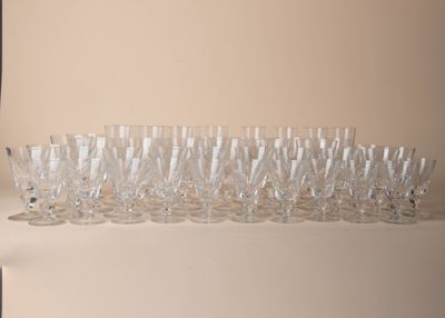 bottles and glasses are lined up on a shelf in a room