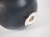 a black vase with a hole in the middle of it