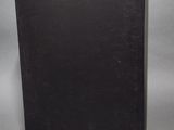 a black book sitting on top of a table next to a gray wall