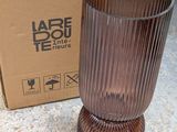 a brown vase sitting next to a box on the ground