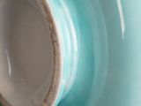 a close up view of a blue vase with a brown rim