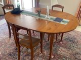 une photo d'une table de salle à manger avec des chaises et un tapis