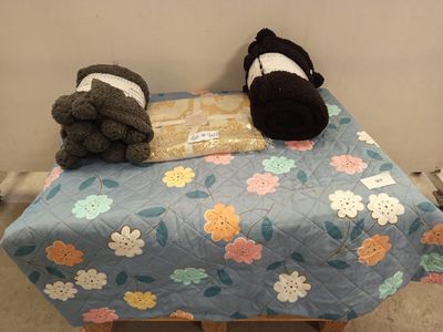 deux peluches assises sur un lit, à côté d'un livre