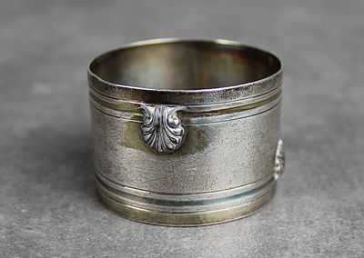 une bague en argent ornée d'une fleur, posée sur une table