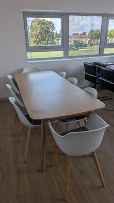 une table et des chaises dans une pièce donnant sur un champ