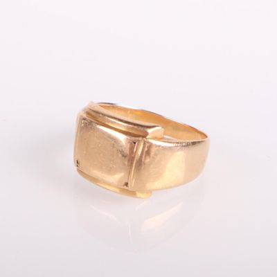 une image représentant une bague en or posée sur une surface blanche