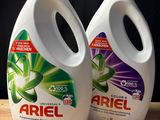 deux bouteilles de lessive liquide Ariel posées sur une table en bois