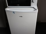 a microwave sitting on top of a refrigerator in a room