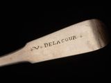 an old wooden spoon with the word v delacour engraved on it