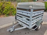 a small trailer with a trailer attached to it in the parking lot
