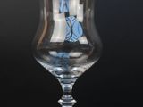 a glass with a sail on it sitting on a table