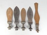 four different types of knives are lined up on a white surface
