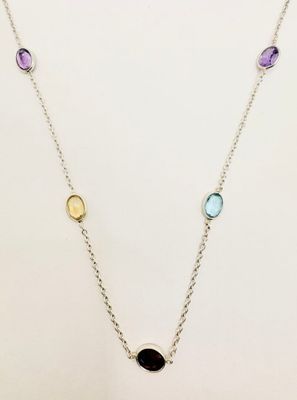 a necklace with multi colored stones on a silver chain