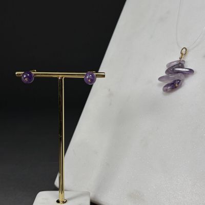 Ensemble composé d'un collier et de boucles d'oreilles en améthorate violet, présenté sur un présentoir plaqué or