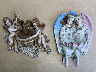 deux figurines d'anges accrochées l'une à côté de l'autre au mur
