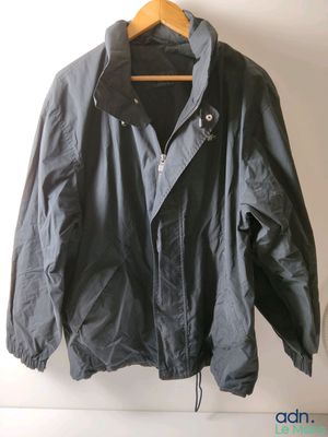jacket hanging on a hanger on a white wall in a room
