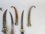 several knives are lined up on a white surface with a white background