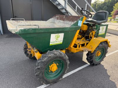 un tracteur vert et jaune garé sur un parking