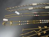 many different types of necklaces and bracelets laid out on a table
