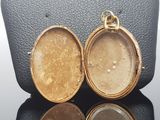 two gold lockes sitting on top of a black surface