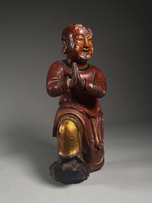 an old wooden statue of a man sitting on a chair