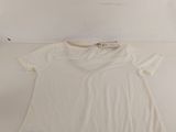 a white t shirt sitting on top of a white table