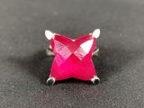pink star shaped ring with silver accents on a black surface