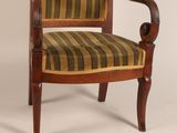 a wooden chair with striped upholstered seat and arms