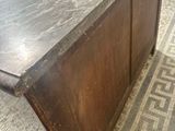 a very old wooden table with a marble top