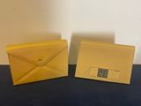 a pair of yellow envelopes sitting on top of a table
