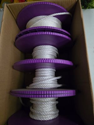 une boîte contenant tout un tas de bobines violettes et blanches